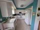 Clean kitchen with white cabinets, essential appliances, and teal accents throughout the room at 5800 Sabal Trace Dr # 1201, North Port, FL 34287