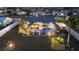 Backyard aerial view with a screened-in pool, outdoor seating, lush landscaping and exterior lighting at 6286 Coniston St, Port Charlotte, FL 33981