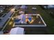 Aerial view of a fenced-in backyard with a screened pool, tropical landscaping, and exterior lighting at 6286 Coniston St, Port Charlotte, FL 33981