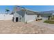 View of the home's side and garage with a paver driveway and well-kept landscaping at 6286 Coniston St, Port Charlotte, FL 33981