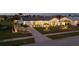 Inviting home with a metal roof, exterior lighting, a manicured lawn, and mature palm trees at 6286 Coniston St, Port Charlotte, FL 33981