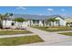 Attractive single-story home with a metal roof and landscaped front yard with palm trees and a concrete driveway at 6286 Coniston St, Port Charlotte, FL 33981