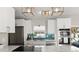 Beautiful kitchen features white cabinetry, stainless steel appliances, eye-catching backsplash, and updated lighting fixtures at 6286 Coniston St, Port Charlotte, FL 33981