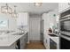 Stylish kitchen with white cabinets, stone countertops, stainless steel appliances, and modern pendant lighting at 6286 Coniston St, Port Charlotte, FL 33981