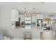Modern kitchen features white cabinets, stainless steel appliances, pendant lighting, and a breakfast bar at 6286 Coniston St, Port Charlotte, FL 33981