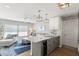 Open-concept kitchen and living area featuring white countertops, wine cooler, stylish seating, and pendant lighting at 6286 Coniston St, Port Charlotte, FL 33981