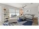 Comfortable living room featuring a stylish rug, a ceiling fan, a plush sofa, and natural light through window blinds at 6286 Coniston St, Port Charlotte, FL 33981