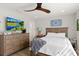 Spacious bedroom featuring a wooden dresser with a television, a fan and comfortable furniture at 6286 Coniston St, Port Charlotte, FL 33981