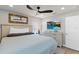 Bright main bedroom featuring wood-look floors, a ceiling fan, and a stylish, wood-framed mirror at 6286 Coniston St, Port Charlotte, FL 33981