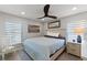 Calm primary bedroom with ceiling fan, two large windows, painting, and a decorative mirror above the bed at 6286 Coniston St, Port Charlotte, FL 33981