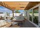Inviting covered patio area with comfortable seating, wood pergola, and view of the landscaped backyard and screen enclosure at 6286 Coniston St, Port Charlotte, FL 33981