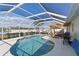 Gorgeous screened-in pool area with covered lanai, wood pergola, BBQ, and spacious patio seating; ideal for outdoor relaxation at 6286 Coniston St, Port Charlotte, FL 33981