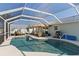 Inviting screened-in pool area featuring a covered patio with comfortable seating and a barbecue grill at 6286 Coniston St, Port Charlotte, FL 33981