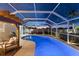 Beautifully lit screened-in pool with a covered patio and outdoor furniture, ideal for relaxation at 6286 Coniston St, Port Charlotte, FL 33981