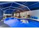 Screened-in pool area featuring a pergola with outdoor seating and lush landscaping at 6286 Coniston St, Port Charlotte, FL 33981