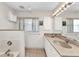 Bright bathroom featuring double sinks, a soaking tub, and built-in shelving at 78 Zenith St, Port Charlotte, FL 33954