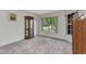 Carpeted bedroom featuring a display cabinet, closet, and windows providing natural light and green outdoor views at 78 Zenith St, Port Charlotte, FL 33954
