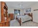 Comfortable bedroom featuring wood furniture, ceiling fan, and a window with views of the landscaped yard at 78 Zenith St, Port Charlotte, FL 33954