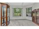 Carpeted bedroom featuring display cabinets and windows providing natural light and green outdoor views at 78 Zenith St, Port Charlotte, FL 33954