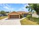Charming single-story home with well-manicured lawn, attached garage, and security gate at entry under a clear blue sky at 78 Zenith St, Port Charlotte, FL 33954