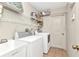 Functional laundry room featuring a washer, dryer, utility sink, and ample shelving for storage at 78 Zenith St, Port Charlotte, FL 33954