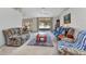 Bright living room with a ceiling fan, neutral carpet, cozy furniture, and a large sliding glass door to the backyard at 78 Zenith St, Port Charlotte, FL 33954
