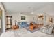 Spacious living room with a ceiling fan, neutral carpet, cozy furniture, and entryway with decorative glass doors at 78 Zenith St, Port Charlotte, FL 33954