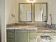 Bathroom featuring dual mirrors, granite countertops, decorative tile, and vanity seating at 876 Golden Beach Blvd # 876, Venice, FL 34285