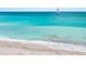 Sandy beach with clear turquoise water and a sailboat in the distance at 876 Golden Beach Blvd # 876, Venice, FL 34285