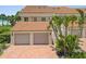 Charming coastal condo featuring private garages, brick driveway, lush landscaping, and beach access at 876 Golden Beach Blvd # 876, Venice, FL 34285