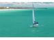 Sailboat gliding in turquoise waters near a beach with pier in background at 876 Golden Beach Blvd # 876, Venice, FL 34285