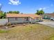 Charming single-story home with manicured landscaping and mature trees in a bright blue sky at 10517 Greenway Ave, Englewood, FL 34224