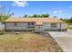 Charming single-story home with gray exterior, brown roof and manicured front lawn at 10517 Greenway Ave, Englewood, FL 34224