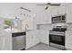 Modern kitchen featuring white cabinets, stainless appliances, and integrated dishwasher at 10517 Greenway Ave, Englewood, FL 34224