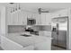 Stylish kitchen with white cabinetry, stainless steel appliances, and quartz countertops at 10517 Greenway Ave, Englewood, FL 34224