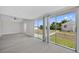 Spacious living room with floor-to-ceiling sliding glass doors overlooking the lush backyard at 10517 Greenway Ave, Englewood, FL 34224