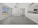 Bright living room features a large window and stylish wood-look flooring, flowing into the kitchen at 10517 Greenway Ave, Englewood, FL 34224
