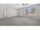 Bright and open living room with sleek flooring, large window, and view of front door at 10517 Greenway Ave, Englewood, FL 34224