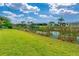 Backyard view of a waterway from a lush green lawn with palm trees at 13284 Amaryllis Cir, Port Charlotte, FL 33981
