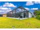Expansive green backyard with a screened in pool area and adjacent houses at 13284 Amaryllis Cir, Port Charlotte, FL 33981