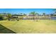 A large waterfront backyard featuring lush green grass, landscaping, and water views at 13284 Amaryllis Cir, Port Charlotte, FL 33981