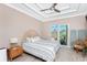 Bright bedroom features a ceiling fan, a TV and direct access to a screened lanai at 13284 Amaryllis Cir, Port Charlotte, FL 33981