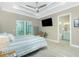 Bright bedroom features a ceiling fan, a TV and direct access to a screened lanai at 13284 Amaryllis Cir, Port Charlotte, FL 33981