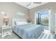 This bedroom features a sliding glass door, side tables with lamps, and coastal-themed décor at 13284 Amaryllis Cir, Port Charlotte, FL 33981