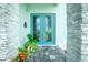 Elegant double front doors with glass accents, surrounded by stone detailing and vibrant plants at 13284 Amaryllis Cir, Port Charlotte, FL 33981
