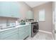 Well-appointed laundry room with sink, cabinets, countertop space, and modern washer and dryer at 13284 Amaryllis Cir, Port Charlotte, FL 33981