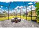 Enclosed patio with stylish stone flooring and comfortable furniture offering scenic views of the lake and backyard at 13284 Amaryllis Cir, Port Charlotte, FL 33981