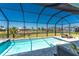 Beautiful backyard featuring a sparkling pool, spa, and scenic views of the lake enhanced by a screened enclosure at 13284 Amaryllis Cir, Port Charlotte, FL 33981