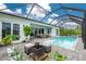 Stunning view of the pool and spa featuring elegant tiling, a screened enclosure, and a cozy lounge area at 13284 Amaryllis Cir, Port Charlotte, FL 33981