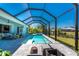 Lovely backyard featuring a sparkling pool and spa with screened-in lanai overlooking mature landscaping at 13284 Amaryllis Cir, Port Charlotte, FL 33981